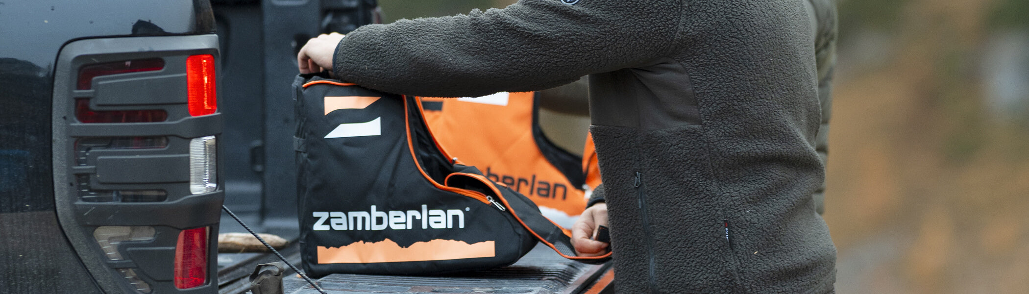 A man opening his black Zamberlan boot case. 