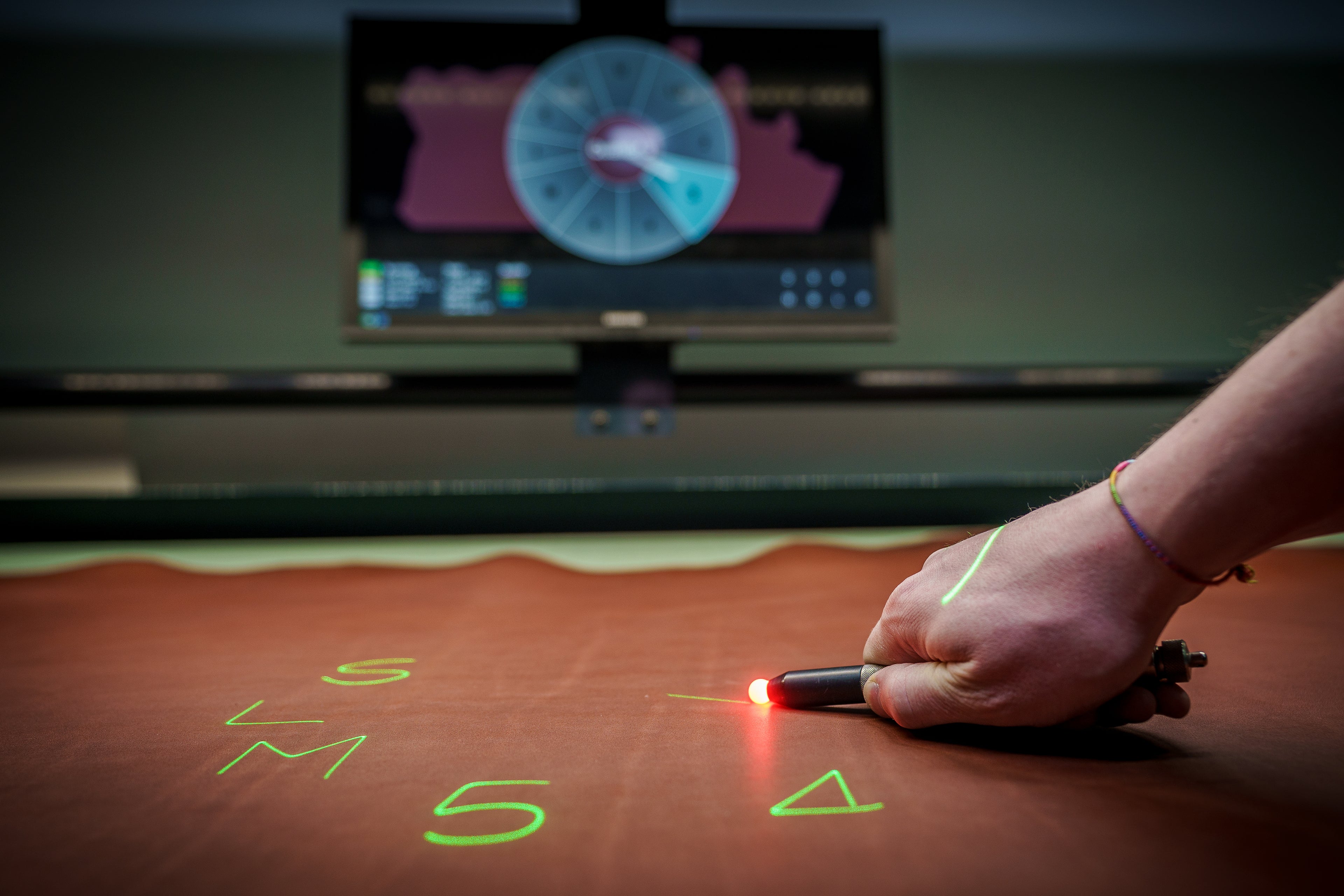 Man mapping out boot design on leather. 